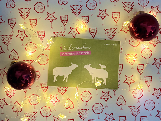 KI generiert: Ein Geschenkgutschein mit Schafmotiv, umgeben von Lichterkette und Weihnachtskugeln. Text: "Räubersachen Geschenk-Gutschein".