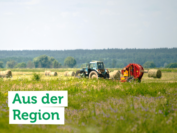 raktor auf einem Feld mit Heuballen. Text auf dem Bild: "Aus der Region".