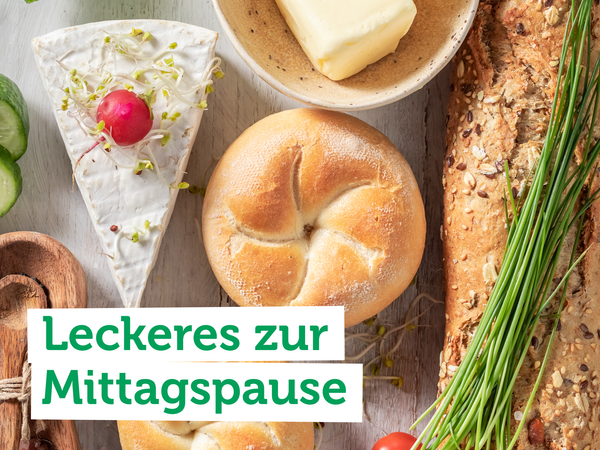 KI generiert: Verschiedene Brote, Käse und Gemüse mit Text: "Leckeres zur Mittagspause".
