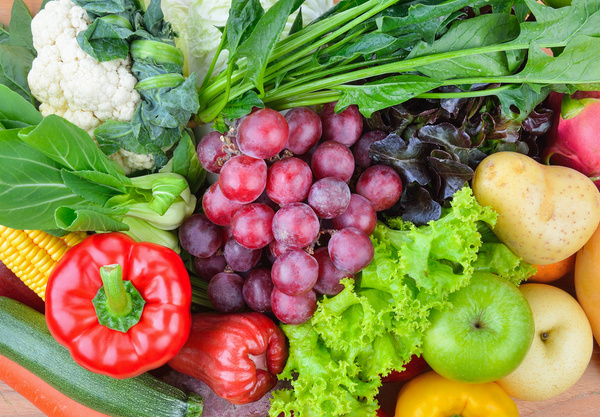 KI-generierte Beschreibung: Das Bild zeigt eine Auswahl an frischem Obst und Gemüse, darunter Äpfel, Trauben, Tomaten, Gurken und Blumenkohl.