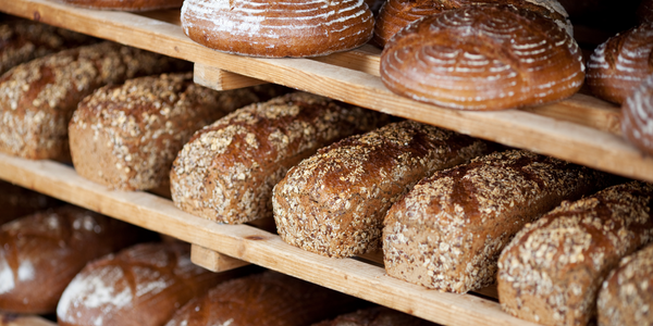 KI generiert: Regale voller frisch gebackenem Brot in verschiedenen Formen und Belägen.