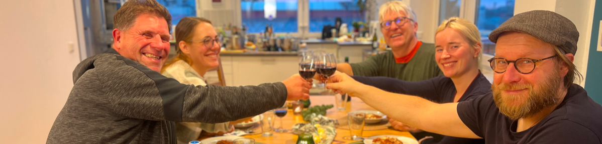 KI-generierte Beschreibung: Gruppe von Menschen bei einer Feier mit Essen und Getränken.
