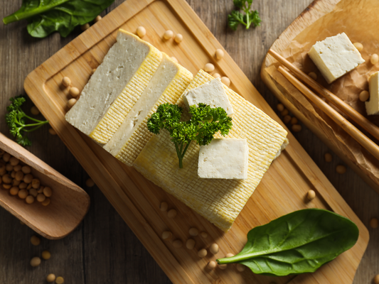 KI generiert: Ein Holzbrett mit geschnittenem Tofu, Petersilie und Sojabohnen.