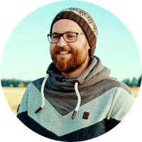 KI generiert: Ein Mann mit Brille und Mütze lächelt im Freien.