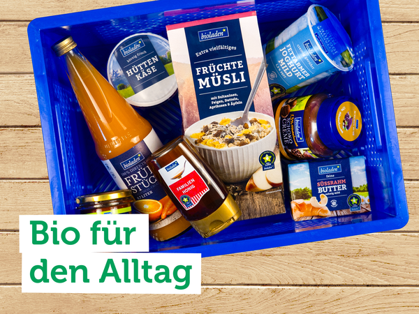 Eine blaue Kiste mit verschiedenen Bioprodukten. Text auf dem Bild: "Bio für den Alltag".
