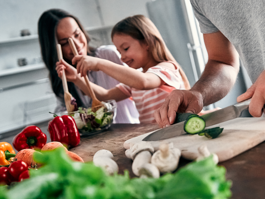KI generiert: Familie bereitet zusammen frisches Gemüse in der Küche zu.