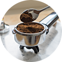 KI generiert: Löffel füllt Kaffeepulver in Siebträger ein.