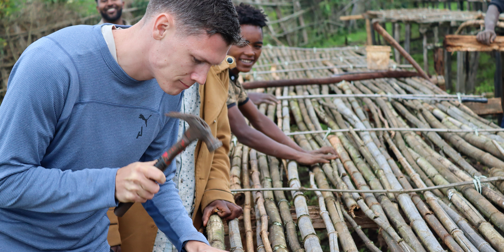 KI generiert: Personen arbeiten gemeinsam an einer Konstruktion aus Bambus und Holz.