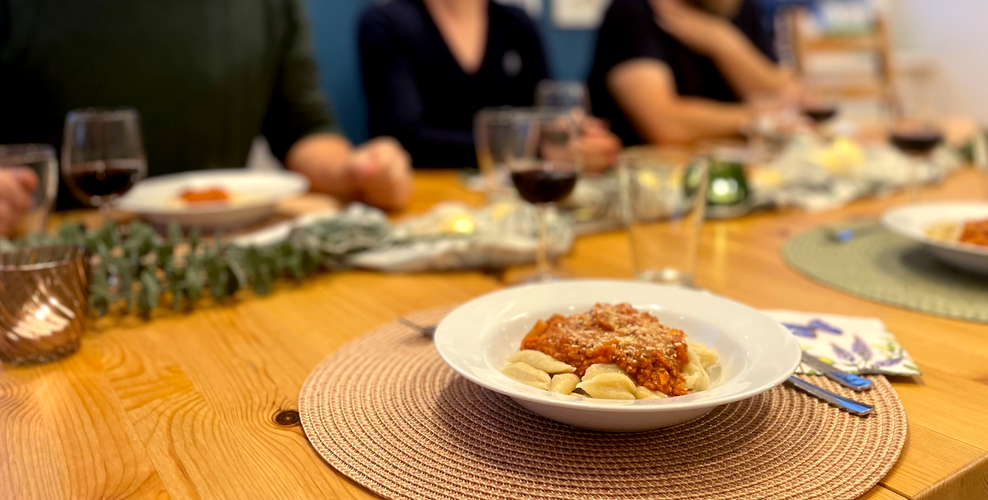 KI generiert: Ein gedeckter Tisch mit mehreren Tellern Pasta und Weingläsern, um den Menschen sitzen.