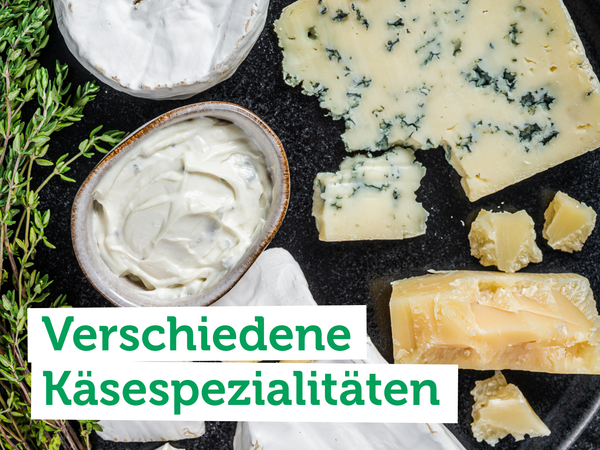 KI generiert: Verschiedene Käsesorten auf dunklem Teller, daneben Kräuter.  
Text: "Verschiedene Käsespezialitäten".