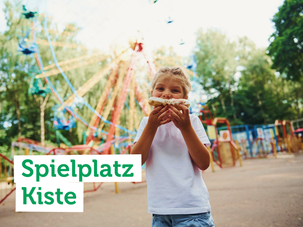 KI generiert: Ein Kind isst eine Süßigkeit vor einem Riesenrad. Text: "Spielplatz Kiste".