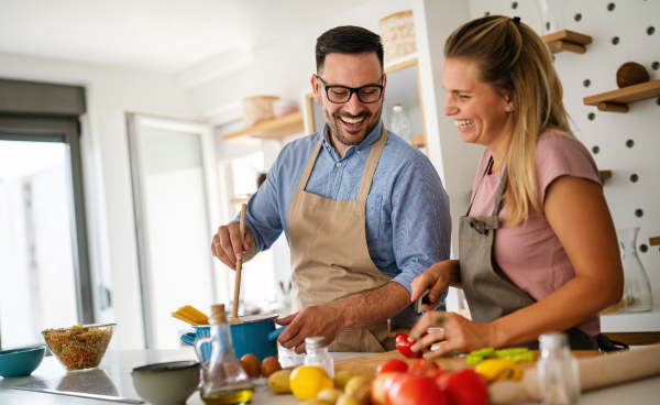 KI generiert: Ein Paar kocht gemeinsam in einer modernen Küche, umgeben von frischem Gemüse und Zutaten.