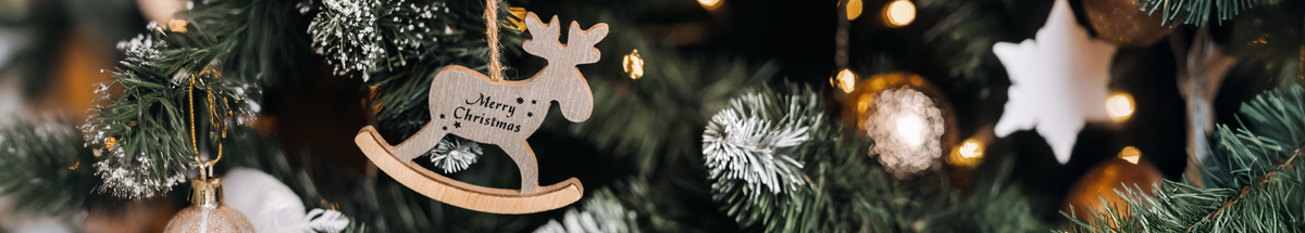 KI generiert: Weihnachtlicher Schmuck an einem Tannenbaum; ein Holz-Elch mit "Merry Christmas".