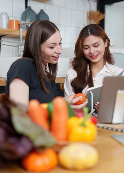 Zwei Frauen am Küchentisch mit Obst und Gemüse